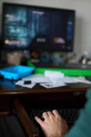 Teenage boy playing computer games at his desk