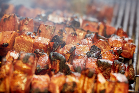 Grilling assorted meat skewers outdoorsの写真素材