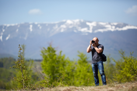 Tourist with camera shooting gorgeous mountain landscapeの写真素材