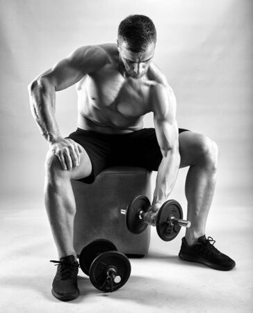 Fitness model working out with weights on gray backgroundの写真素材