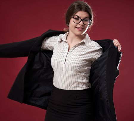 Closeup of an attractive businesswoman on red backgroundの写真素材