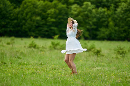Gorgeous beauty model in summer dress dancing outdoor in an oak forestの写真素材