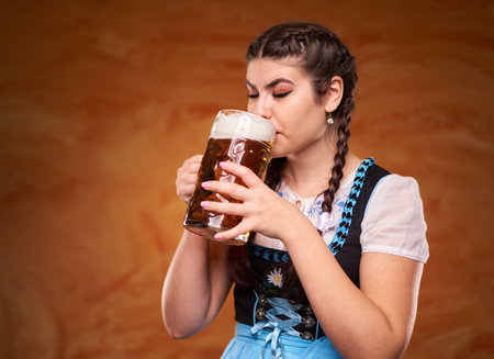 German girl in traditional costume drinking large pints of lagerの写真素材