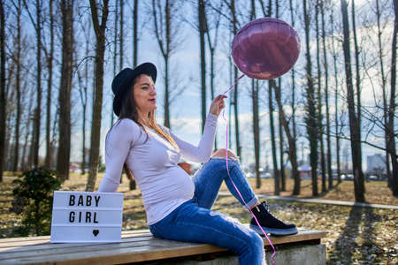 Young hispanic pregnant woman outdoor in the park