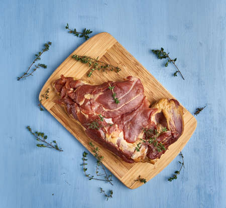 Smoked pork leg on a wooden board in closeup