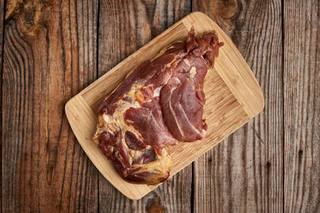 Smoked pork leg on a wooden board in closeupの写真素材