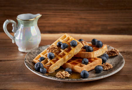 Waffles with blueberries and walnuts glazed in maple syrupの写真素材