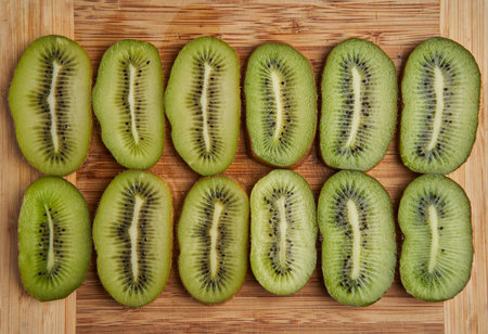 Closeup of freshly sliced kiwi fruits on a wooden boardの写真素材