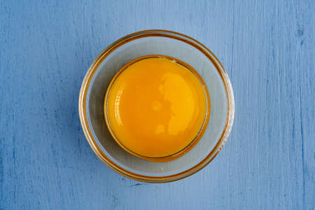 Raw egg yolk on blue backgroundの写真素材