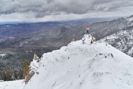 Shirtless strong man on top of the mountain in the winter, bravely facing the elementsの写真素材