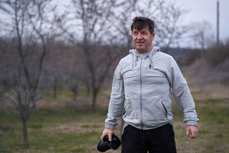 Professional photographer taking pictures in a buckthorn orchard in the early springの写真素材