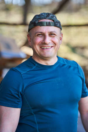 Happy lumberjack with sawdust on his face smiling in a closeup portrait