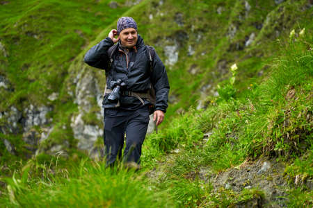 Professional nature photographer hiking into the mountains in a rainy day