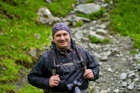 Professional nature photographer hiking into the mountains in a rainy dayの写真素材