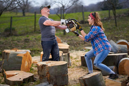 Husband offering a chainsaw as gift for his wife