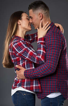 Young caucasian couple posing against gray background