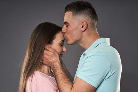 Young caucasian couple posing against gray background