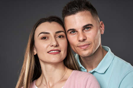 Young caucasian couple posing against gray background