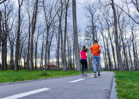 Athletic and attractive young couple running in the park