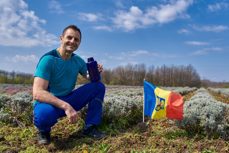 Proud romanian farmer drinking water near his lavender field