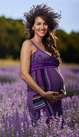 Beautiful young pregnant woman in a lavender field in full bloomの写真素材