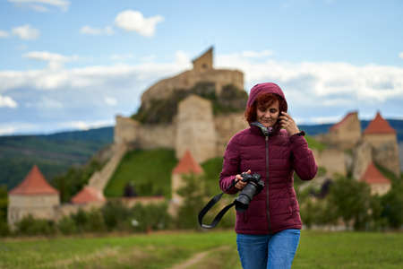 Woman tourist with camera visiting a medieval fortressの写真素材