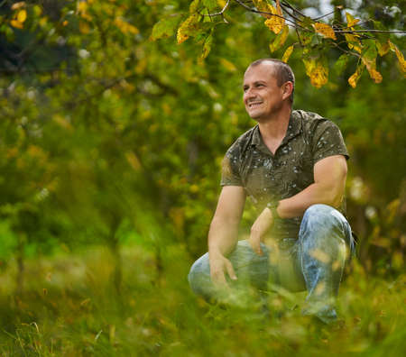 Portrait of a middle aged man in the orchard, early autumn