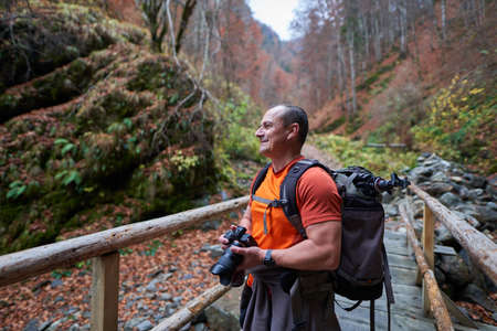 Travel photographer in a beautiful autumnal scene in the mountainsの写真素材