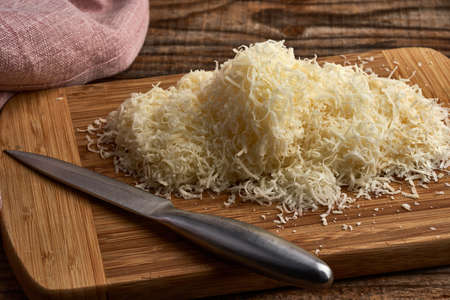 Portion of parmesan grated from a large block of parmigiano reggiano