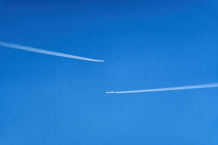 Two airplanes in the sky closely passing by each other