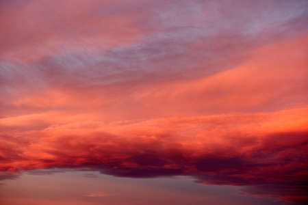 Vibrant cloudscape with orange clouds at sunset, useful as a backdropの写真素材