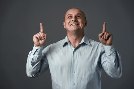 Mature businessman indicating above the image to the copyspaceの写真素材