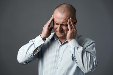 Mature businessman with a strong migraine because of work related stressの写真素材