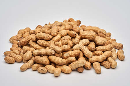 Closeup of a pile of dried peanuts isolated on white background