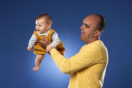 Father having a great time with his baby daughter, studio shot