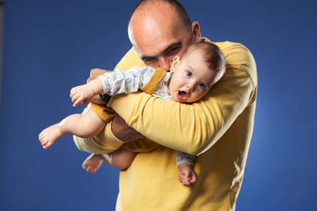 Father having a great time with his baby daughter, studio shotの写真素材