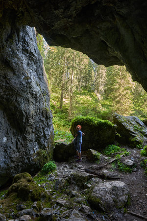 Woman hiker with backpack exploring a cave undergroundの写真素材