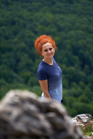 Woman with backpack hiking in the mountains on a trail