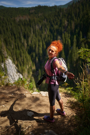 Woman hiker with backpack hiking into the mountain forestの写真素材
