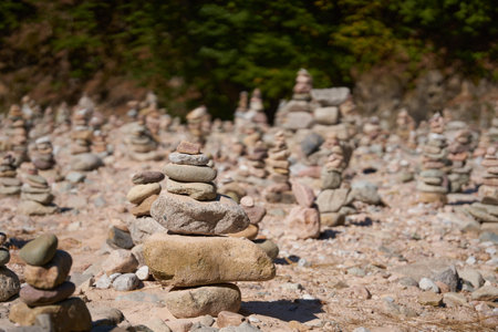 River pebbles and stones arranged in tower structures on the shoreの写真素材