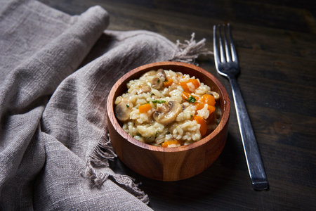 Thai recipe of boiled and fried rice with mushrooms and herbs and veggies in a rustick bowlの写真素材