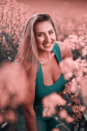 Beautiful sensual woman in dual tone pink and teal image in a canola field