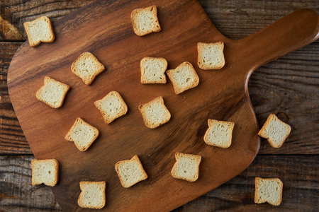 Bruschetta mini breads, dried, on a wooden board, in flat layの写真素材