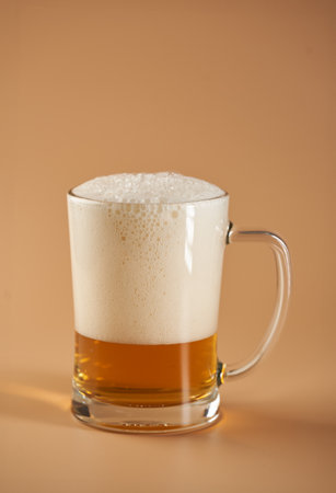 A pint of beer in various foam stages on beige backgroundの写真素材