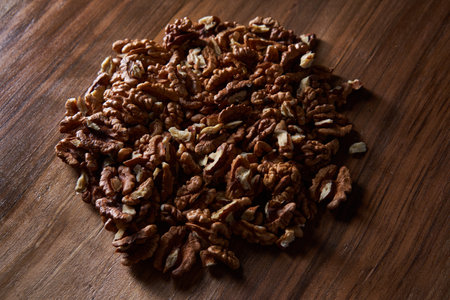 Flat lay shot of a pile of walnuts on a wooden board