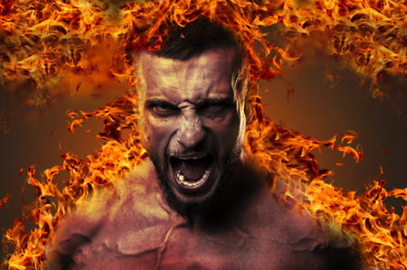 Conceptual image of a shirtless fighter unleashing a war scream while engulfed in flamesの写真素材