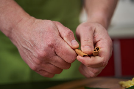 Man breaking a cinnamon stick over a wooden board
