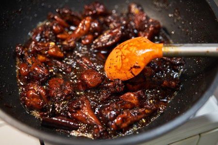 Cooking caramelized chicken wings in a wok, a thai speciality recipeの写真素材