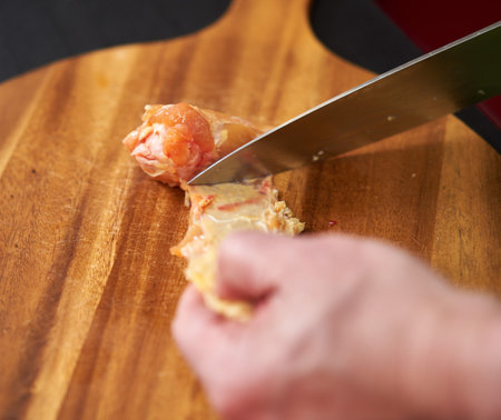Cook removing chicken skin from wings for a recipe without cholesterol