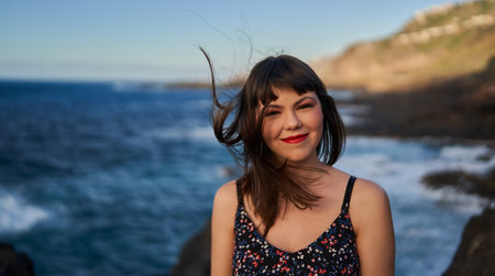 Holiday in Tenerife - portrait of a beautiful young woman by the ocean at sunset in the Canary...
